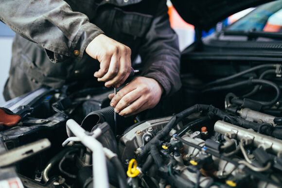 A mechanic fixing a car motor at an auto repair shop